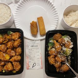 China Chef - Left Orange Flavor Chicken. Right Sesame Chicken. Both come with White Rice. On plate left is Roast Pork Egg Roll and right is Spring Roll.