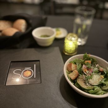 Sol St Pete Bistro - Salad in the front and bread basket in the back with the garlic oil. - New American Near Me - St. Petersburg, Florida Sol St Pete Bistro - Salad in the front and bread basket in the back with the garlic oil. - New American Near Me - St. Petersburg, Florida