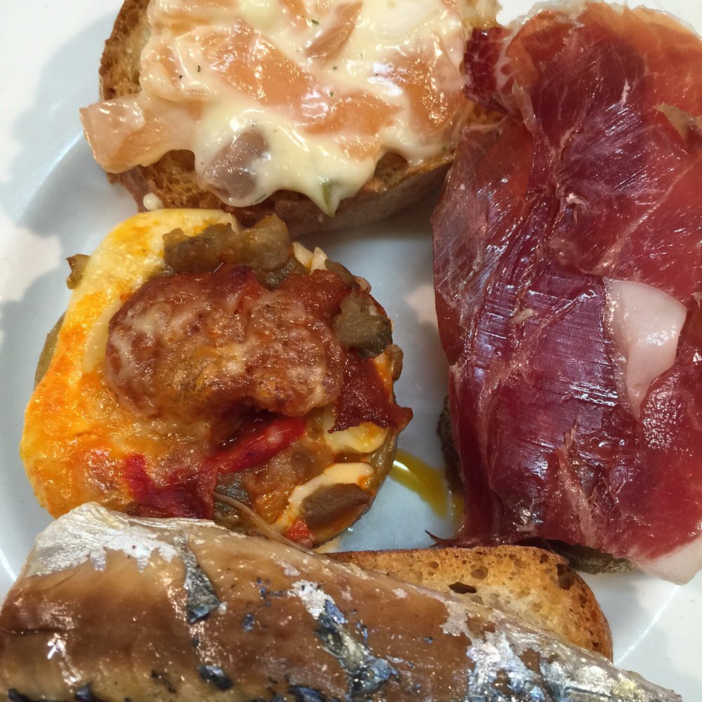 El Xampanyet - Assorted tapas: Potato and chorizo, salmon salad, jamon Iberico, sardine - Tapas Bars Near Me - Barcelona, B El Xampanyet - Assorted tapas: Potato and chorizo, salmon salad, jamon Iberico, sardine - Tapas Bars Near Me - Barcelona, B