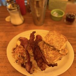 Western Cafe - The Bobcat -- cinnamon roll French toast w/ hash browns, two farm fresh eggs over easy, and bacon and an iced tea.