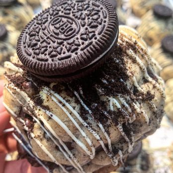 Krammed Kookies - a hand holding an oreo doughnut - Desserts Near Me Krammed Kookies - a hand holding an oreo doughnut - Desserts Near Me