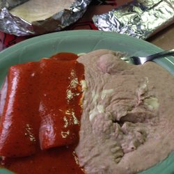 Tiny cheese enchiladas swimming in sauce and beans  that look like they came out of a can.