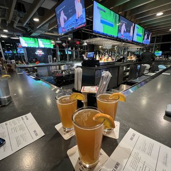 Drive Shack - three glasses of orange juice on a bar - Golf Near Me - Orlando, Florida