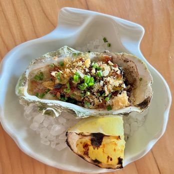 Half Shell - Roasted oyster with green garlic butter, bacon, and grilled lemon - Bars Near Me - Seattle, Washington Half Shell - Roasted oyster with green garlic butter, bacon, and grilled lemon - Bars Near Me - Seattle, Washington