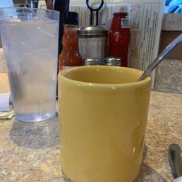 a yellow mug with a spoon in it a yellow mug with a spoon in it