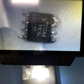 Penguin Locksmith - A digital microscope captures a close-up image of an electronic component, likely a relay or integrated circuit, with visible pins and markings. - Keys & Locksmiths Near Me - Tucson, Arizona