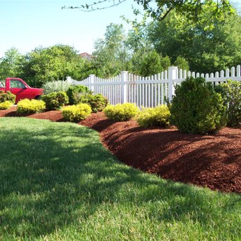 Ascencio Landscaping - a red pickup truck parked in front of a white picketed fence - Landscaping Near Me