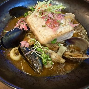 Limón - DORADO EN SALSA DE MARISCOS Pan-seared Mahi-Mahi served over braised seafood, Chardonnay ají amarillo sauce, & aromatic herbs. - Peruvian Near Me - Walnut Creek, California
