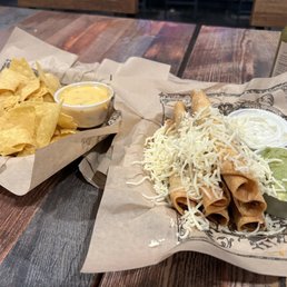 Small order of chips and queso and taquitos with a side of guac and sour cream Small order of chips and queso and taquitos with a side of guac and sour cream