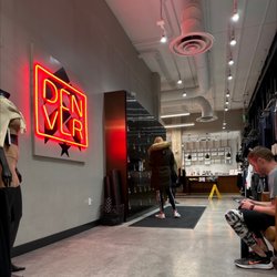 Barry's Denver - Hallway with lockers, foam rollers, benches, and smoothie bar at the end