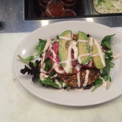 Hooked Cafe - Quinoa burger over a salad with avocado and a zesty tahini dressing.
