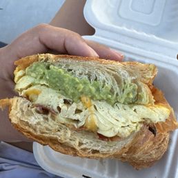 Bacon, egg, cheese, with avocado on a wonderful flaky croissant. Perfectly balanced sandwich. Bacon, egg, cheese, with avocado on a wonderful flaky croissant. Perfectly balanced sandwich.