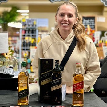 Skyline Liquors & Wines - a woman behind a table with bottles of liquor - Beer, Wine & Spirits Near Me - Towson, Maryland Skyline Liquors & Wines - a woman behind a table with bottles of liquor - Beer, Wine & Spirits Near Me - Towson, Maryland