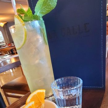 La Calle - mexican mojito and 2oz. pour of Raicilla served with orange slices with smoked flakes. - Mexican Near Me - Baltimore, Maryland La Calle - mexican mojito and 2oz. pour of Raicilla served with orange slices with smoked flakes. - Mexican Near Me - Baltimore, Maryland