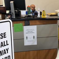 AutoNation Honda O'Hare Service Center - This is a photo of a service desk employee with his mask under his chin asleep on the phone while there were 3 people waiting in line.