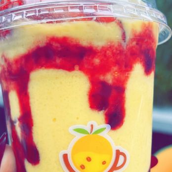 Vara juice - Arisi drink - A yellow fruit smoothie topped with strawberries and drizzled with red syrup, served in a clear cup with Vara Juice branding. - Juice Bars & Smoothies Near Me - Bridgeview, Illinois