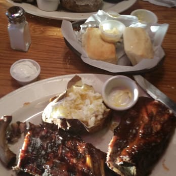Logan's Roadhouse - Full order of baby back ribs (I ate one rib already), baked potato and bread rolls- yum! - Steakhouses Near Me - Redding, California