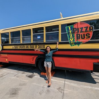 Izzy's Pizza Bus - a woman standing in front of a pizza bus - Food Trucks Near Me - Omaha, Nebraska Izzy's Pizza Bus - a woman standing in front of a pizza bus - Food Trucks Near Me - Omaha, Nebraska