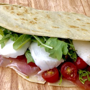 Flatbread Factory - a closeup of a sandwich on a cutting board - Food Trucks Near Me Flatbread Factory - a closeup of a sandwich on a cutting board - Food Trucks Near Me