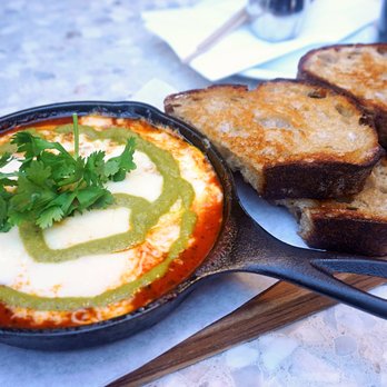 Interstellar - Shakshuka: harissa tomato marinara, nuoc mam cilantro, three eggs, melted mozzarella, jalapeño sauce, toast ($27). - Coffee & Tea Near Me - Santa Monica, California Interstellar - Shakshuka: harissa tomato marinara, nuoc mam cilantro, three eggs, melted mozzarella, jalapeño sauce, toast ($27). - Coffee & Tea Near Me - Santa Monica, California