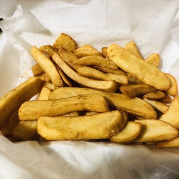 Roasted Pepper - Steak fries. Perfect side - A portion of French fries with a golden-brown exterior is shown in a paper-lined container. The fries vary in size and shape, and the container appears to be part of a casual dining or takeout setting, with the focus on the fried potato sticks. - American Near Me - Leominster, Massachusetts