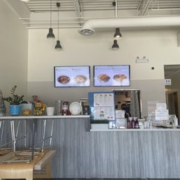 a restaurant counter with two televisions above it