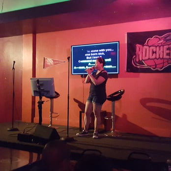 Glitter Karaoke - A picture of a guy taking a picture of a person on stage. I don't know what else to add to this. - Karaoke Near Me - Houston, Texas