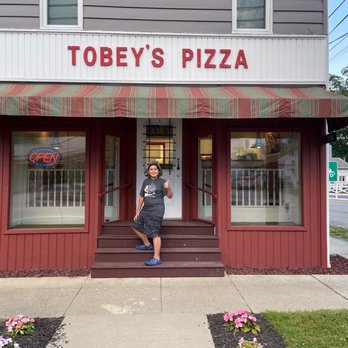 Tobey's Pizza - a woman standing in front of a restaurant - Pizza Near Me - Sandy Lake, Pennsylvania