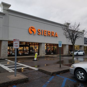 Sierra Poughkeepsie - A Sierra retail store is shown with a parking lot in front, including reserved and no parking signs, and a tree nearby. - Sporting Goods Near Me - Poughkeepsie, New York