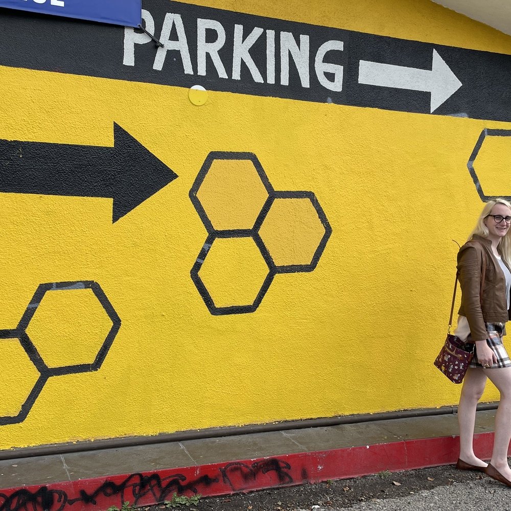 a woman standing in front of a parking sign a woman standing in front of a parking sign