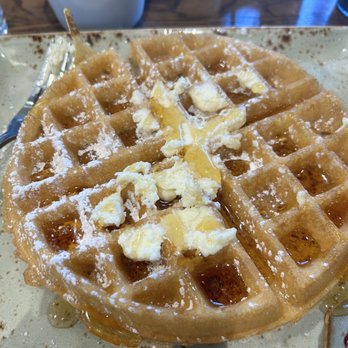 First Watch - Waffle - A waffle with a crispy exterior, topped with melting butter and syrup, served on a plate at a restaurant. - Breakfast & Brunch Near Me - Gilbert, Arizona
