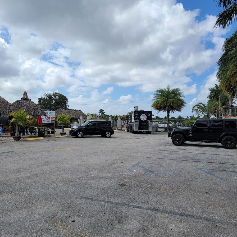 Organic Food Kings - a parking lot with trucks and palm trees - Vegan Near Me - Miami, Florida