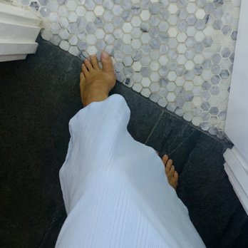 Antonio Tile - the feet of a person standing in a bathroom - Flooring Near Me