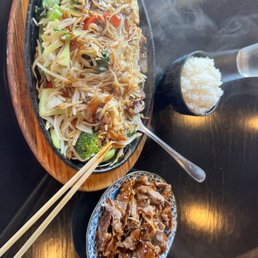 a plate of food with chopsticks and rice