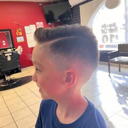 Moe Barbershop & Hair Salon - Fade with hard part and styling on 6 year old