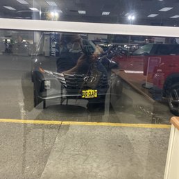 The view of our new car, from the sales desk inside. The view of our new car, from the sales desk inside.