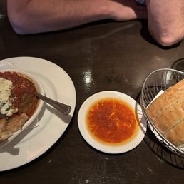 Meatball appetizer and bread with oil for the table.