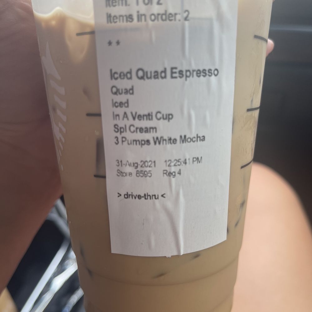 a hand holding a cup of iced coffee a hand holding a cup of iced coffee