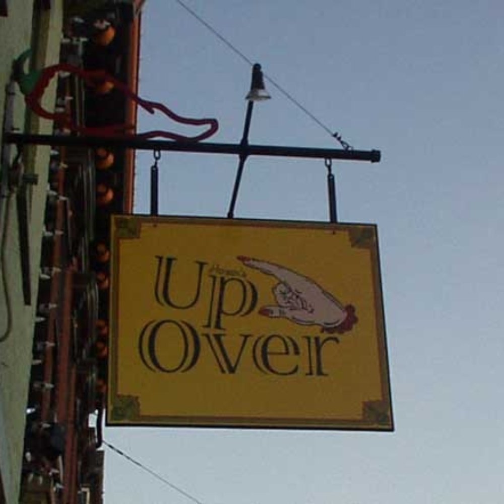 a yellow sign hanging from the side of a building a yellow sign hanging from the side of a building