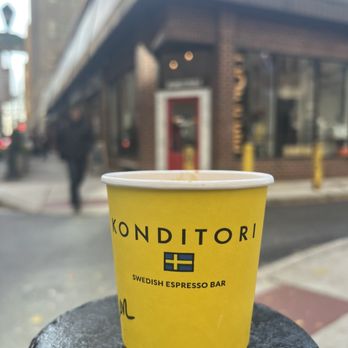 Konditori - a yellow cup sitting on a black post - Coffee & Tea Near Me - Philadelphia, Pennsylvania
