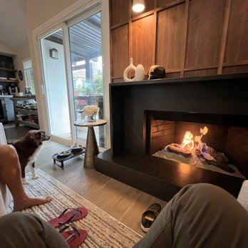 Pacific Landmark - a man and his dog in front of a fireplace - Flooring Near Me - Santa Ana, California
