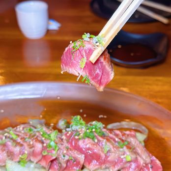 Shakai Sushi Lounge - a person holding chopsticks over a plate of sushi - Lounges Near Me - Orlando, Florida Shakai Sushi Lounge - a person holding chopsticks over a plate of sushi - Lounges Near Me - Orlando, Florida