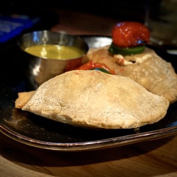 Ceviche's - Jerk Camarones & Tres Queso Empanada: Topped With Roasted Cherry Tomatoes, Jalapeño & Chimichurri Dipping Sauce - Seafood Near Me - Wilmington, North Carolina
