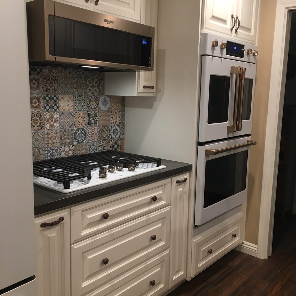 TNT Construction - a kitchen with white cabinets and black countertops - General Contractors Near Me - Fullerton, California TNT Construction - a kitchen with white cabinets and black countertops - General Contractors Near Me - Fullerton, California