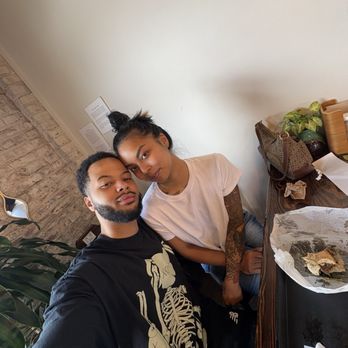 Yorgo's Bageldashery - A man and woman pose for a selfie at a table in an indoor setting, with a white wall and some plants in the background. - Bagels Near Me - Norfolk, Virginia