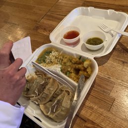 a tray of food with rice, meat, and sauces
