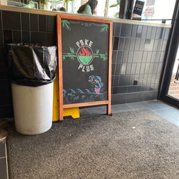 a chalkboard sign and trash can