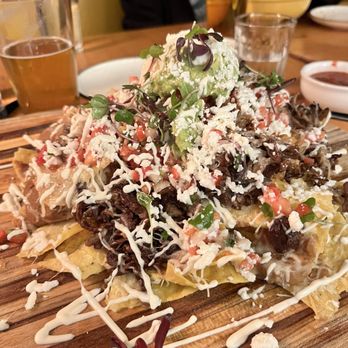 Carmelita’s - Dana Point - Nachos Appetizer (carnitas in place of beef) served on a BIG chopping block! - Mexican Near Me - Dana Point, California Carmelita’s - Dana Point - Nachos Appetizer (carnitas in place of beef) served on a BIG chopping block! - Mexican Near Me - Dana Point, California