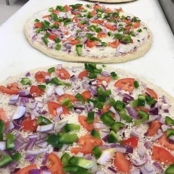 Tito's Pizza - a row of uncooked pizzas - Pizza Near Me - Guelph, Ontario