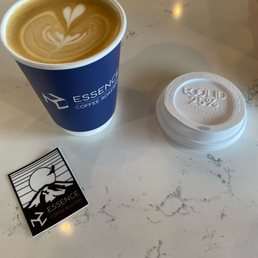 a cup of cappuccino and a sticker